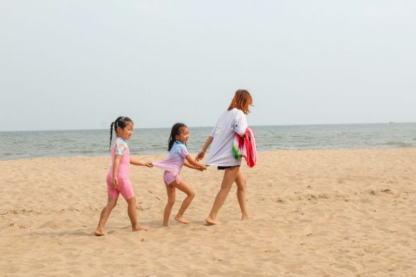 Deux enfant avec une mère sur la plage